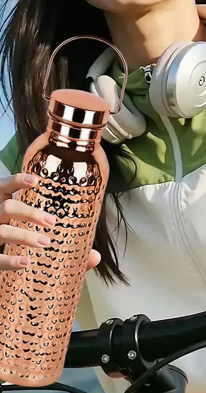The hand-hammered Coppora copper bottle in everyday use on a kitchen counter.